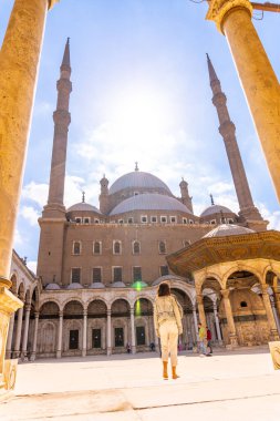 Alabaster Camii 'nin iç avlusunda yürüyen genç bir turist ve Mısır başkentindeki Kahire şehrindeki dev sütunlar. Afrika