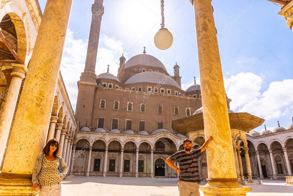 A young tourist looking at the Alabaster Mosque and the gigantic pillars in the city of Cairo, in the Egyptian capital. Africa