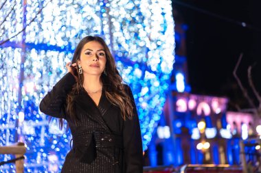 Noel çekimi, genç beyaz tenli esmer Noel 'de şehrin ışıklarının tadını çıkarıyor. Zarif siyah Noel elbisesi