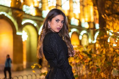 Noel çekimleri, beyaz tenli genç esmerin gece portresi Noel 'de şehrin ışıklarının tadını çıkarıyor. Zarif siyah noel ya da yeni yıl elbisesi