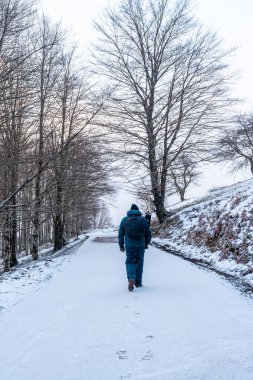 Gipuzkoa 'da Aizkorri Dağı' na tırmanmak için yolda yürüyen genç bir adam. Kış karları altında karlı bir manzara. Bask Ülkesi, İspanya