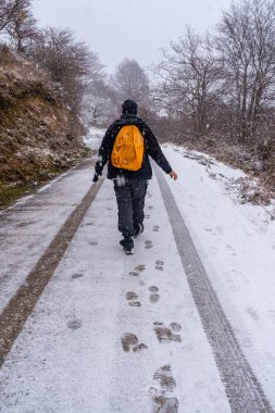 Gipuzkoa Dağı 'nın karlı yolunda eğlenen genç bir adam. Kış karları altında karlı bir manzara. Bask Ülkesi, İspanya