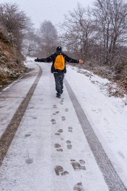 Gipuzkoa Dağı 'nın karlı yolunda eğlenen genç bir adam. Kış karları altında karlı bir manzara. Bask Ülkesi, İspanya