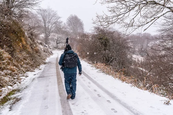Gipuzkoa 'daki Aizkorri Dağı' nın karlı yolunda genç bir fotoğrafçı. Kış karları altında karlı bir manzara. Bask Ülkesi, İspanya