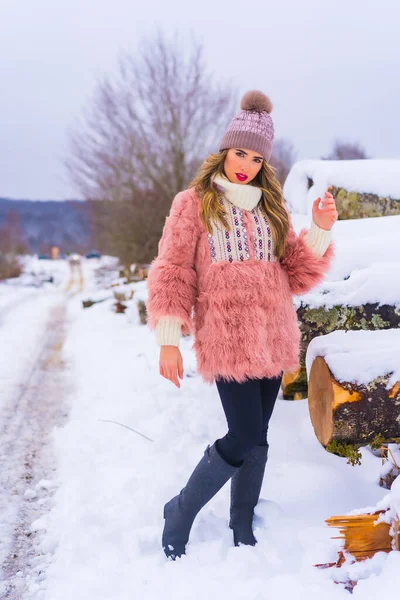 분홍색 털옷을 보라색 모자를 산책로에 얼음으로 옆에서 생활을 — 스톡 사진