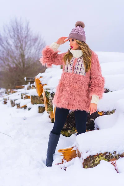 Блондинка Розовой Меховой Куртке Фиолетовой Шляпе Снегу Смотрящая Горизонт Рядом — стоковое фото