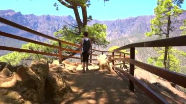 Kanarya Adaları 'ndaki Caldera de Taburiente' nin yanındaki La Palma adasındaki Lomo de las Chozas de La Cumbrecita bakış açısına doğru yürüyen genç bir kadın. İspanya