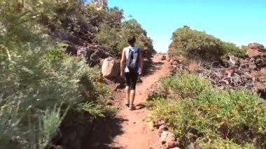 Bir yaz öğleden sonra, Roque de los Muchachos yakınlarındaki Caldera de Taburiente volkanik parkının tepesinde yürüyen genç bir kadın, La Palma, Kanarya Adaları. İspanya