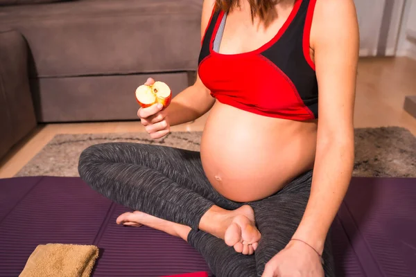 妊娠中の女性の詳細自宅でヨガの練習後にリンゴを食べる 授業前のオンライン演習 — ストック写真