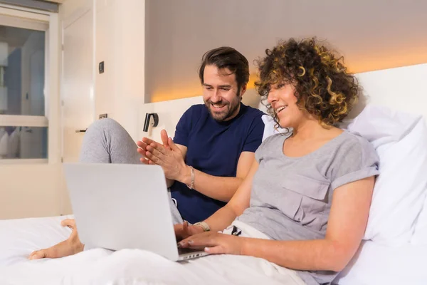 Lifestyle Couple Pajamas Bed Looking Online Reservation Computer — Stock Photo, Image