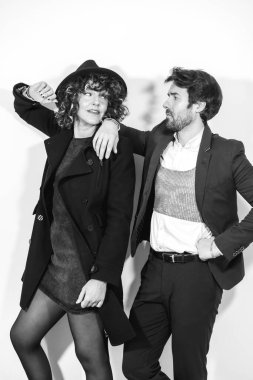 Siyah beyaz bir moda çekiminde beyaz bir çift, şık kıyafetler içinde.