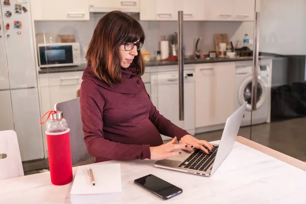 由于工作困难 年轻孕妇在家用电脑远程工作 对工作电话持积极态度 — 图库照片