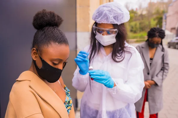 Czarna Dziewczyna Otrzymująca Szczepionkę Przeciw Koronawirusowi Lekarza Oczekującej Nią Innej — Zdjęcie stockowe