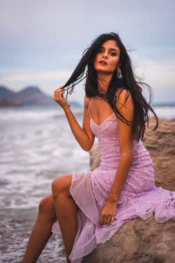 Plajda, Cabo de Gata, Nijar 'da, deniz kenarında, pembe elbiseli esmer bir Kafkasyalı. İspanya 'da Endülüs