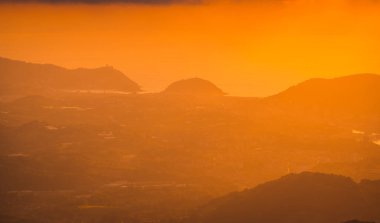 Bir dağın tepesinden güzel bir günbatımında turuncu renklerin derecesi