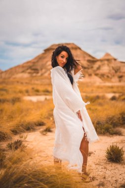 Beyaz elbiseli esmer beyaz bir manken ve güzel çölde eğlenen siyah bir bikini.