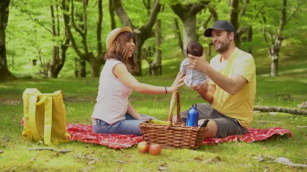 一个家庭在野餐日和他们刚出生的儿子玩耍 穿着黄色 白色的衬衫和帽子 在森林里过着夏天的生活 — 图库视频影像
