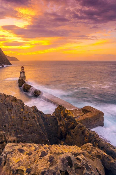 Long exposure in the orange sunset at the lighthouse in the municipality of Pasajes San Juan in Gipuzkoa. Basque Country