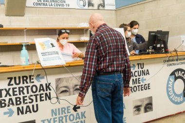 San Sebastian, Gipuzkoa. İspanya. 8 Mayıs 2021: Bir erkek kendini Covid-19 nüfusunun aşı, aşı ve tam bağışıklık merkezinde tanıtıyor. Coronavirüs