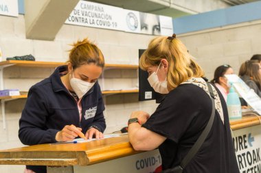 San Sebastian, Gipuzkoa. İspanya. 8 Mayıs 2021: Covid-19 nüfusunun aşı, aşı ve aşı merkezinde kendini tanıtan bir kadın. Coronavirüs