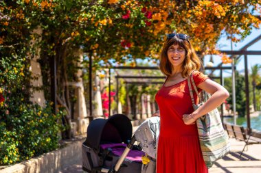 Torrevieja, Alicante, Akdeniz 'deki Parque de las Naciones' de oğluyla birlikte yürüyen genç bir kadın. İspanya