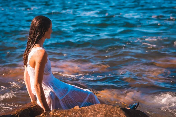 Uma Jovem Mulher Caucasiana Vestido Branco Molhado Sentado Uma Rocha — Fotografia de Stock