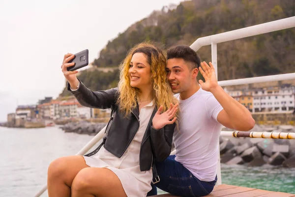 一对白种人夫妇度假时坐在海边拍照时的生活方式 — 图库照片