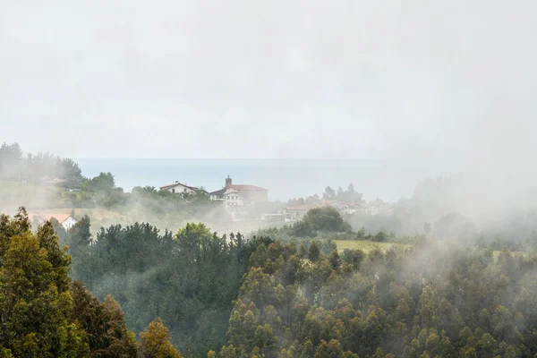 Uma Pequena Cidade Topo Montanha Cheia Neblina Primavera Ispaster Lado — Fotografia de Stock