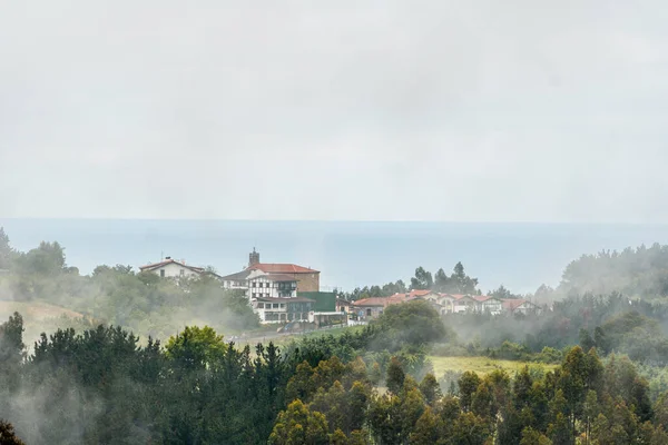 Uma Pequena Cidade Topo Montanha Cheia Neblina Primavera Ispaster Lado — Fotografia de Stock