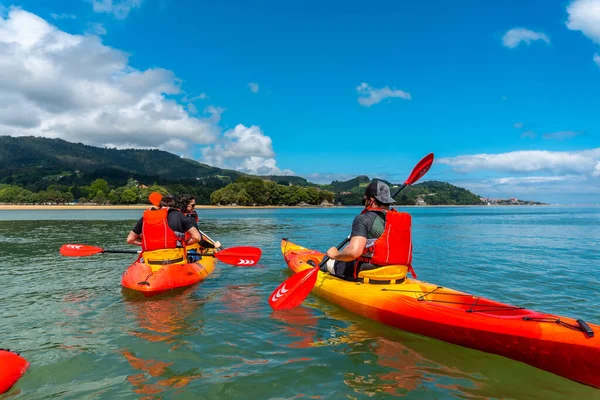 A group of friends on a route with the kayak in the sea in the Urdaibai natural park, Basque country. Bay of Biscay. Spain