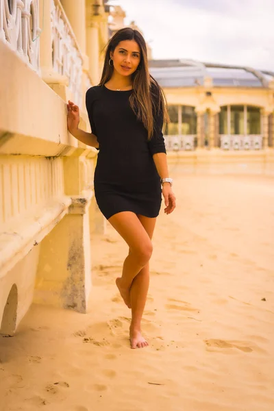 生活方式 一个年轻的黑发白人女人穿着黑色短裙在海滩上享受暑假的肖像 — 图库照片