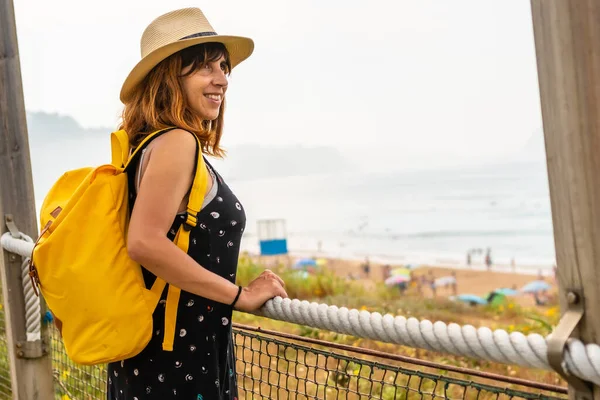 모험심 여자가 모자를 여름을 즐기며 해변에서 바다를 바라본다 — 스톡 사진