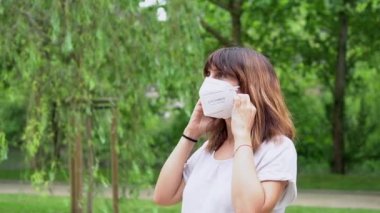 A young woman removing her surgical mask and smiling at the end of the coronavirus pandemic. End of restrictions abroad, happy to be able to breathe well again, covid19, yellow background