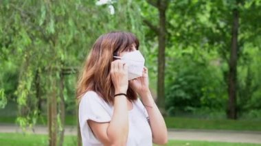 A young woman removing her surgical mask and smiling at the end of the coronavirus pandemic. End of restrictions abroad, happy to be able to breathe well again, covid19, yellow background