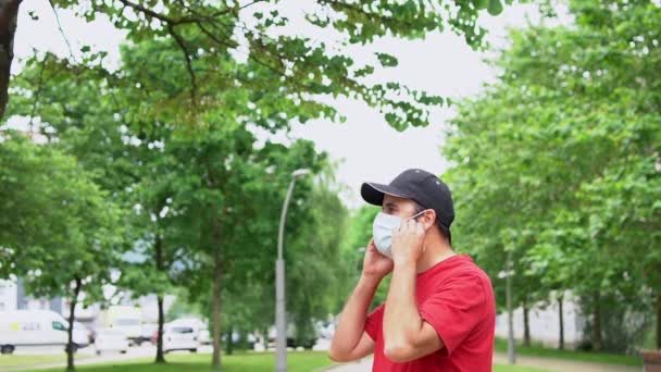 Młody Mężczyzna Czerwonej Koszulce Zdejmuje Maskę Chirurgiczną Pod Koniec Pandemii — Wideo stockowe