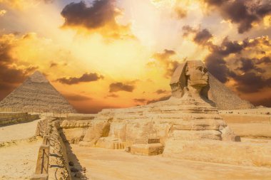 Giza 'nın Büyük Sfenksi ve arka planda bir yaz öğleden sonra Giza Piramitleri, dünyanın en eski Cenaze Anıtı. Mısır 'ın Kahire şehrinde