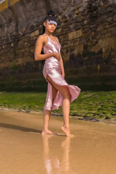多明尼加族女孩 头戴辫子 穿着漂亮的粉色连衣裙 在海滩上享受夏天的时髦姿势 — 图库照片