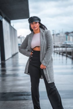 Sonbaharda gezen deri şapkalı ve gri yağmurluklu güzel Latin bir kızın şehri.