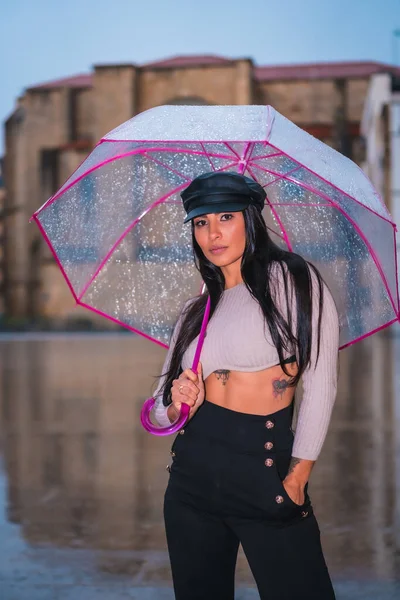 秋天的雨中 一个年轻的拉丁黑发姑娘带着一顶皮帽 带着一把透明的雨伞 — 图库照片