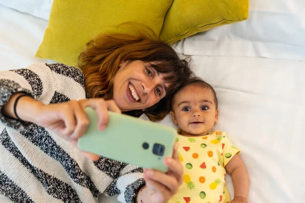 Nuori Äiti Vauva Ottaa Selfien Makuuhuoneessaan Sängyssä Ensimmäistä Kertaa Valkoihoinen — kuvapankkivalokuva