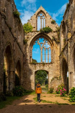Paimpol 'deki Abbaye de Beauport kilisesinin kalıntılarını ziyaret eden genç bir kadın, Ctes de Armor departmanı, Fransız Brittany. Fransa