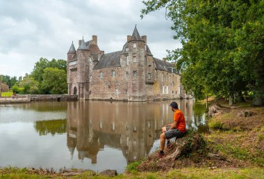 Broceliande Ormanı yakınlarındaki Campnac komünü Trecesson gölü ortaçağ şatosunda genç bir adam..