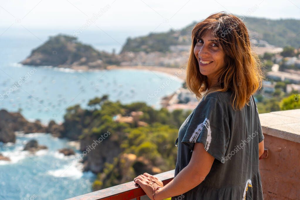 A young tourist looking at Tossa de Mar from the viewpoint, Girona on the Costa Brava of Catalonia in the Mediterranean