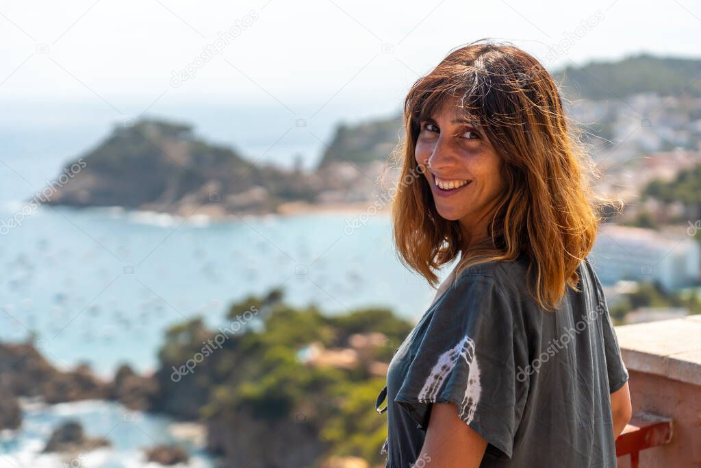 A young tourist looking at Tossa de Mar from the viewpoint in the summer, Girona on the Costa Brava of Catalonia in the Mediterranean