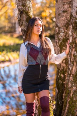 Sonbahar yaşam tarzı, Kafkasyalı genç bir esmer, parktaki bir ağacın yanındaki üniversiteli kız.