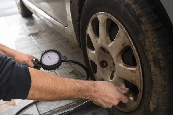 Workshop car inspection, checking the pressure of the wheels with the air gun, annual technical inspection of the vehicle