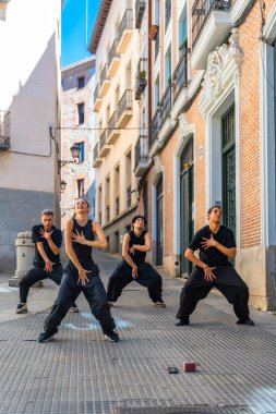 Dar bir Avrupa ara sokağında, hareketlerini ve enerjilerini ifade eden dört genç dansçıdan oluşan bir grup modern dans gösterisi sergiliyor.