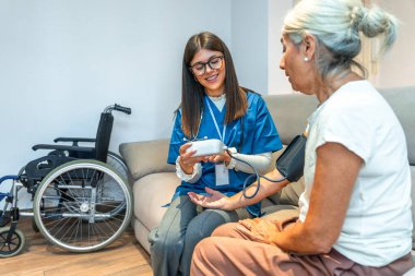 Yaşlı bir hasta için kan basıncını ölçen sağlık uzmanı sağlık ve sağlık hizmetleri sunarken, sağlık ve sağlık izleme hizmetleri sunmaktadır.