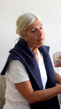 Kadın bir doktor olarak sağlık kontrolünde gülümseyen yaşlı bir kadın kan basıncını ölçmek için tonometre kullanır, yaşlı sağlık hizmetleri, önleme ve düzenli muayenelere odaklanır.