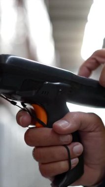 Envanteri taramak, stokları yönetmek ve siparişleri karşılamak için modern bir lojistik ve dağıtım merkezindeki sevkiyatları takip etmek için el bilgisayarı kullanan bir erkek depo çalışanını kapatın.